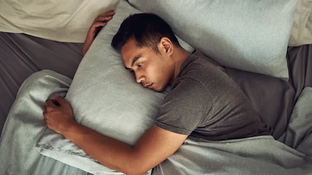 venlafaxine: man alone in bed and hugging a pillow 1332616385