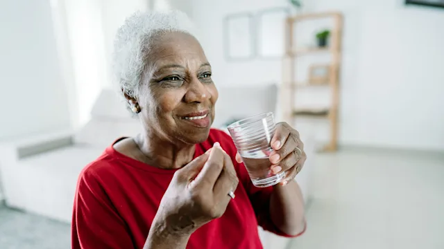 high cholesterol: senior woman taking medicine 1475832063