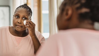 Dermatology: woman using cotton pad on face 1179971783