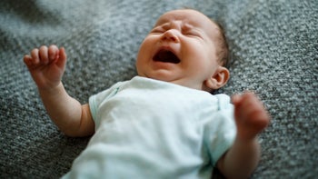 children's health: colic: baby: newborn crying textured blanket background-1215321279