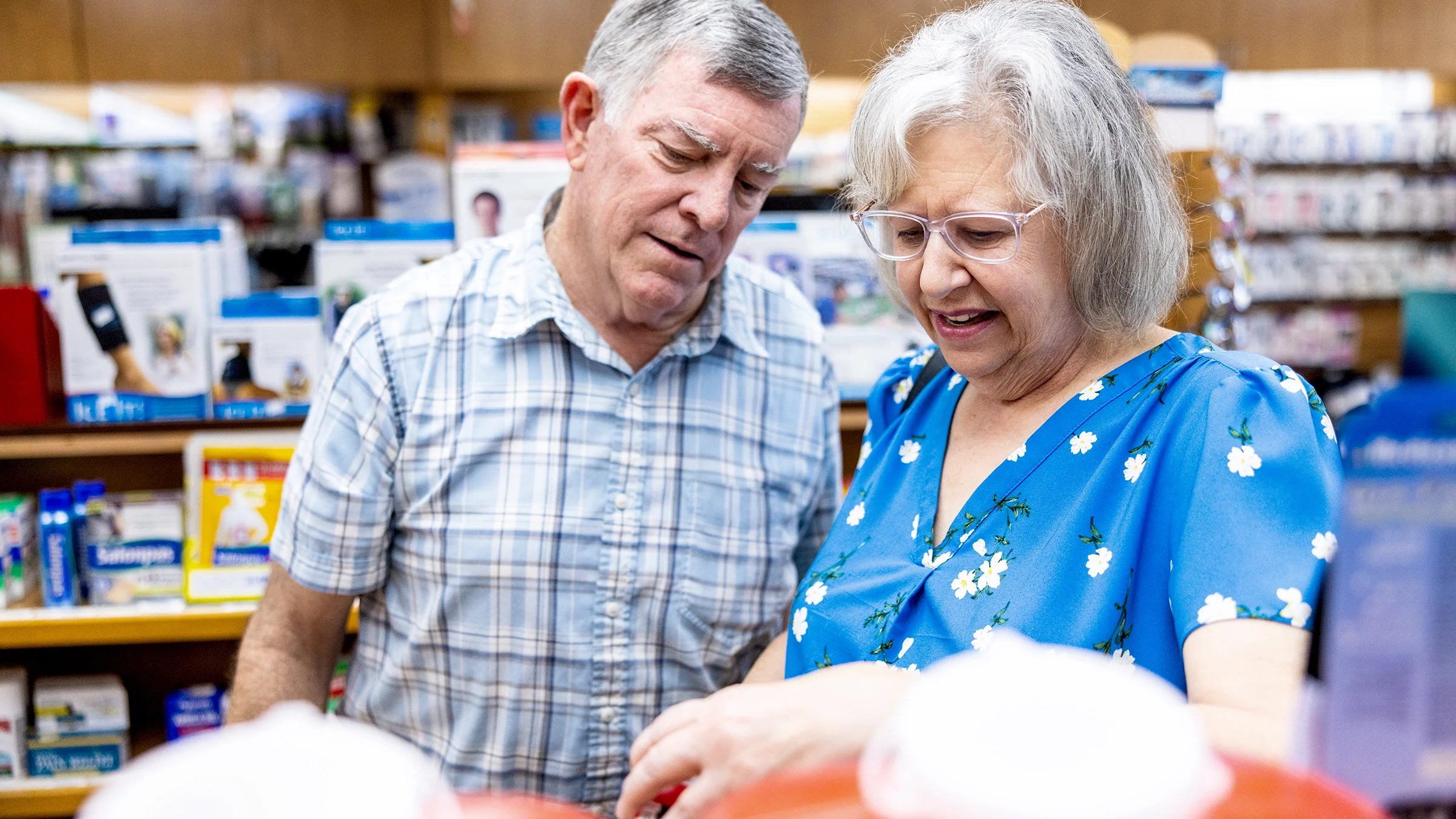 An older couple shop in a pharmacy.