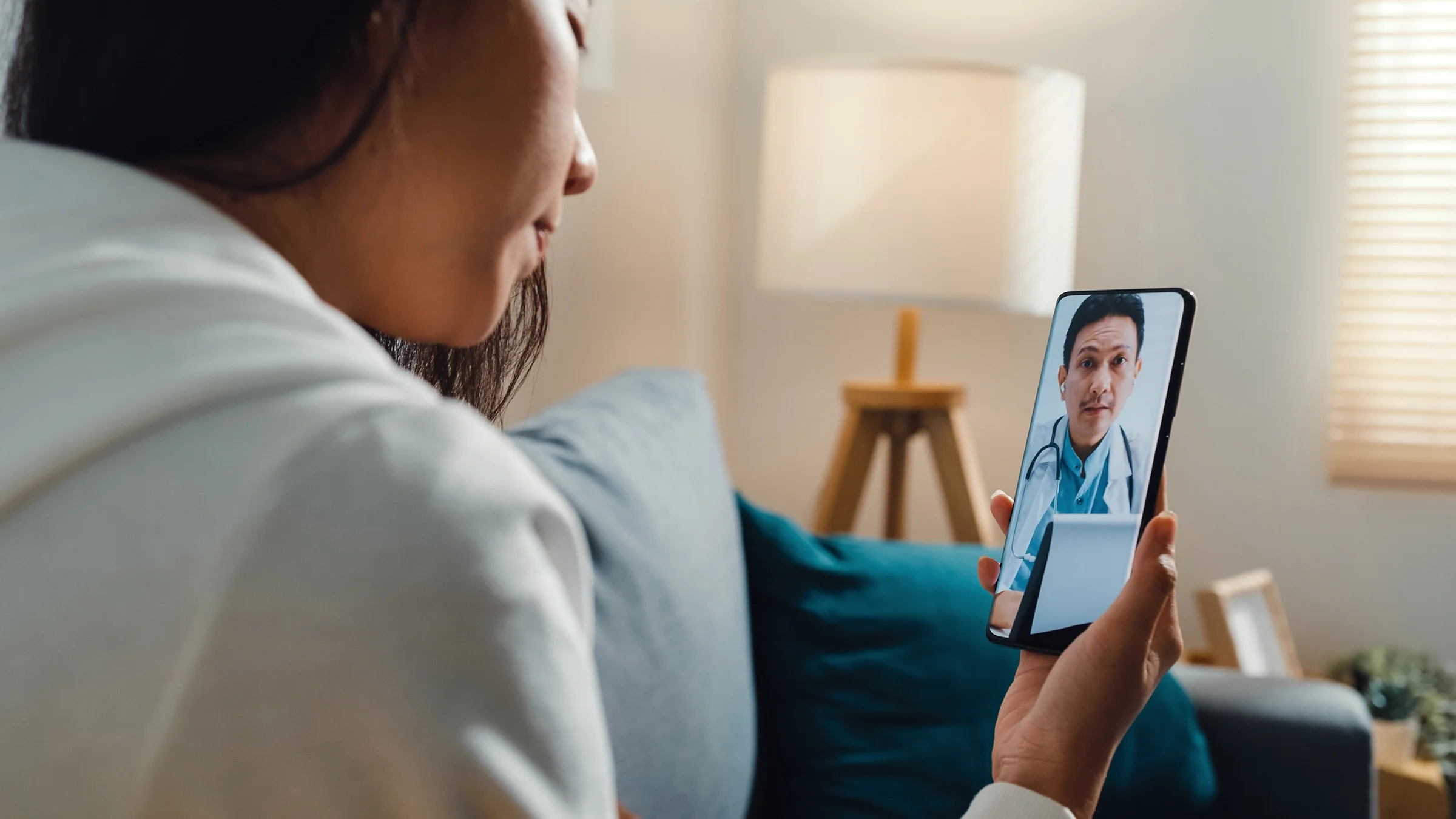 A woman talks to a doctor over the phone during a telemedicine appointment.