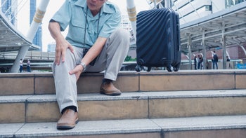 senior man knee pain while traveling-1180154302