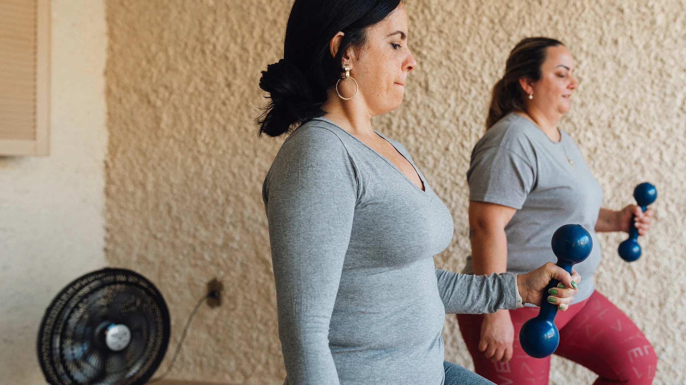 Women strength-train together at home.
Igor Alecsander/E+ via Getty Images