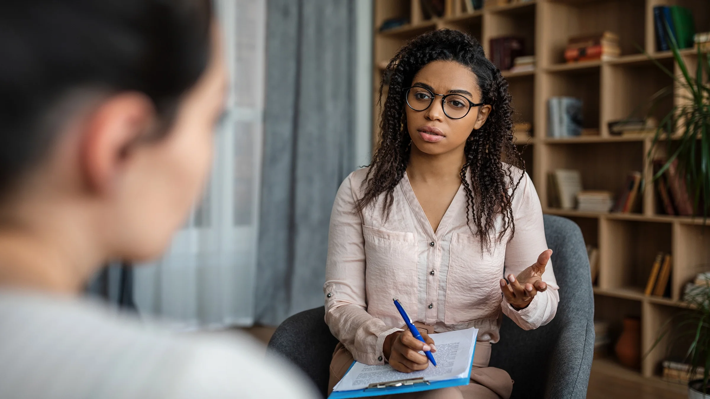 A therapist speaks with a client during their therapy session.