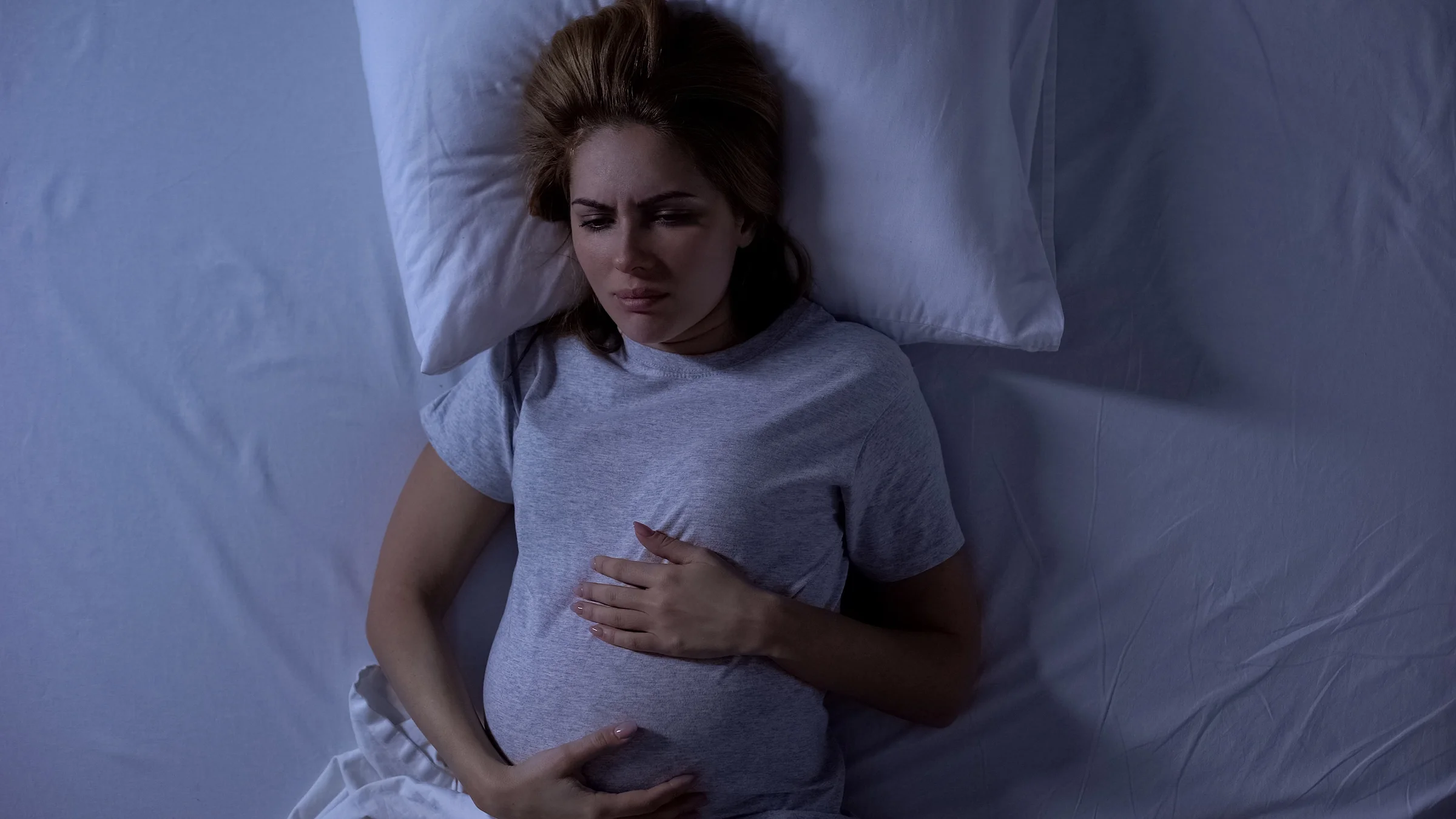 Pregnant woman lying awake at night in bed