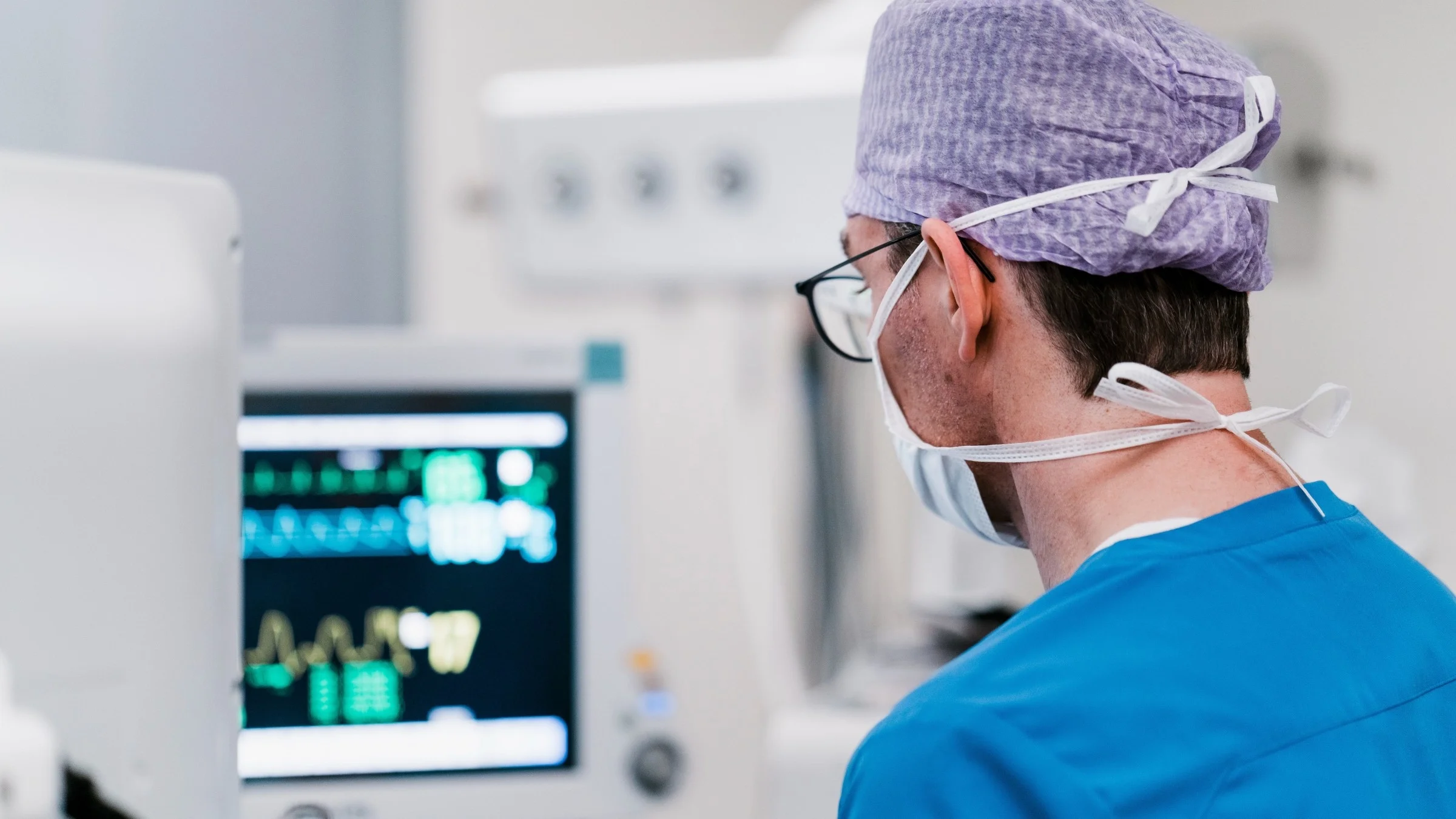Nurse standing next to the digital display in the hospital room.