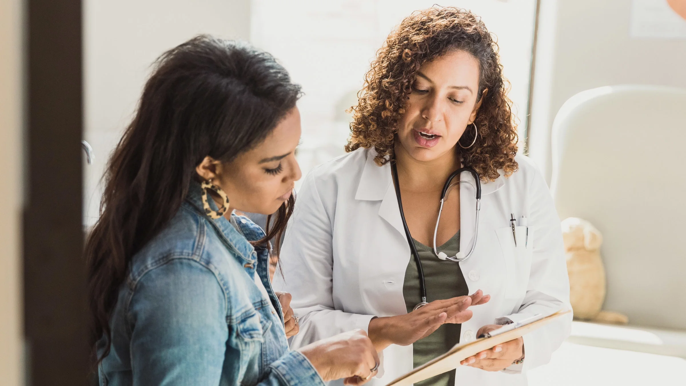 A doctor explaining a clipboard to a patient. 