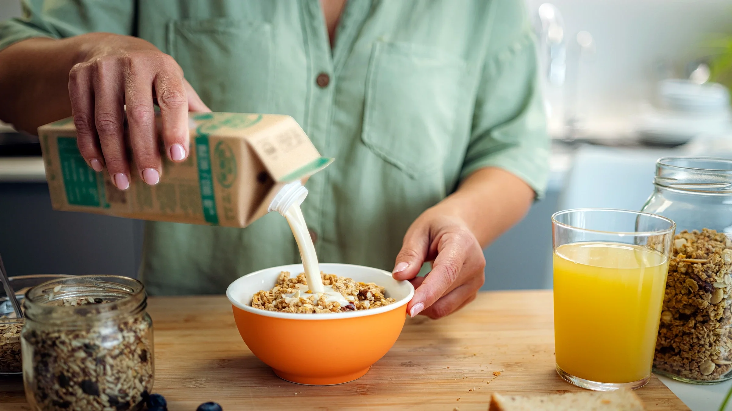 A woman pours milk into a bowl. Full-fat dairy may not be as bad as we once thought.