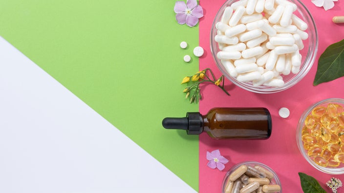 OTC pills and supplements laid out on a colorful background with plants.