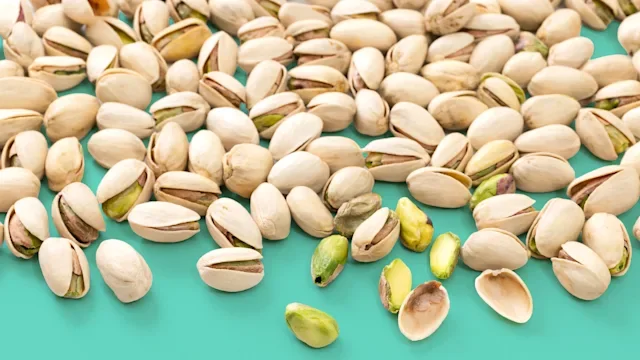 diet-nutrition: pistachios on teal background 2260164979