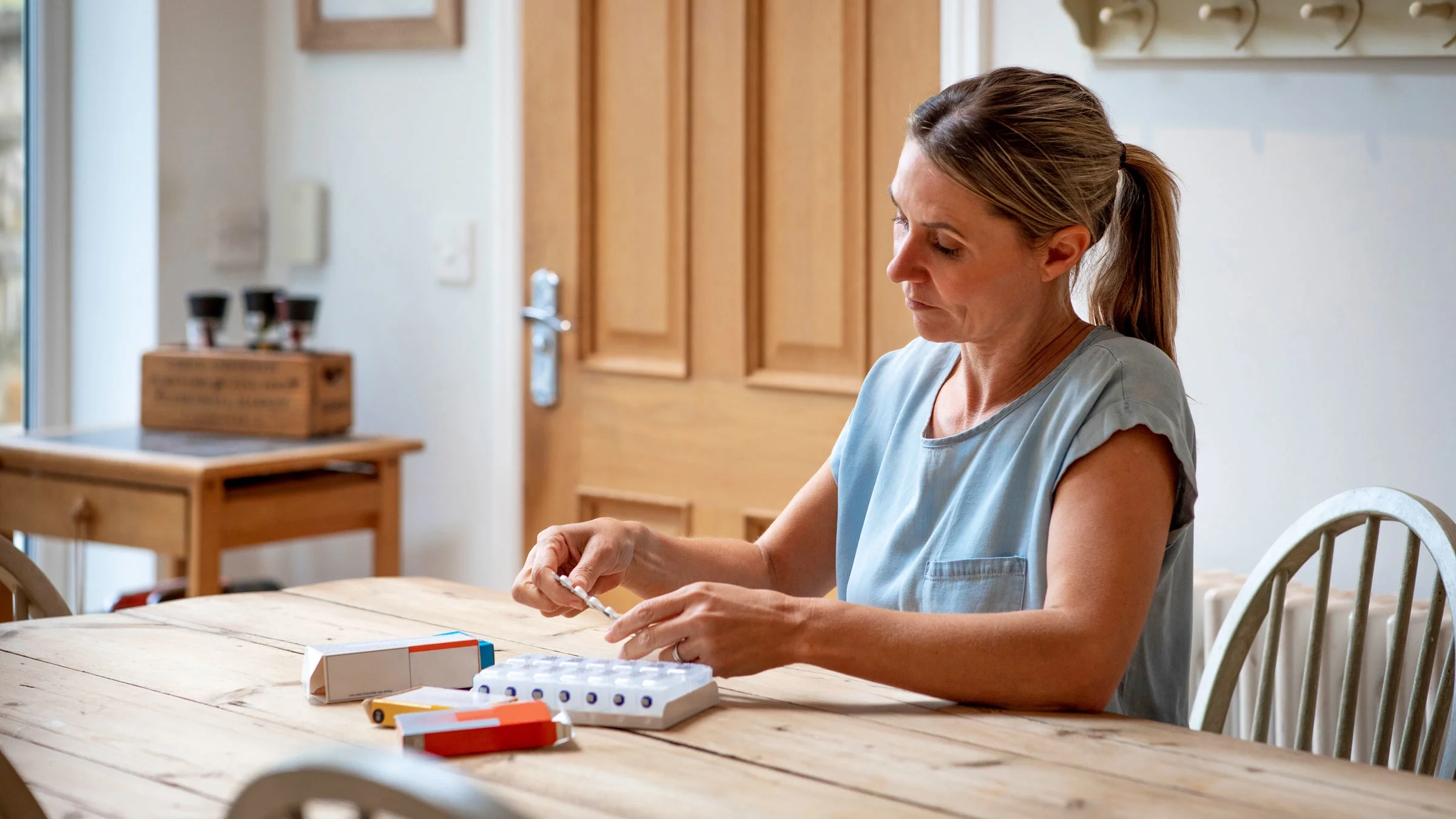 A woman organizes her daily medication.