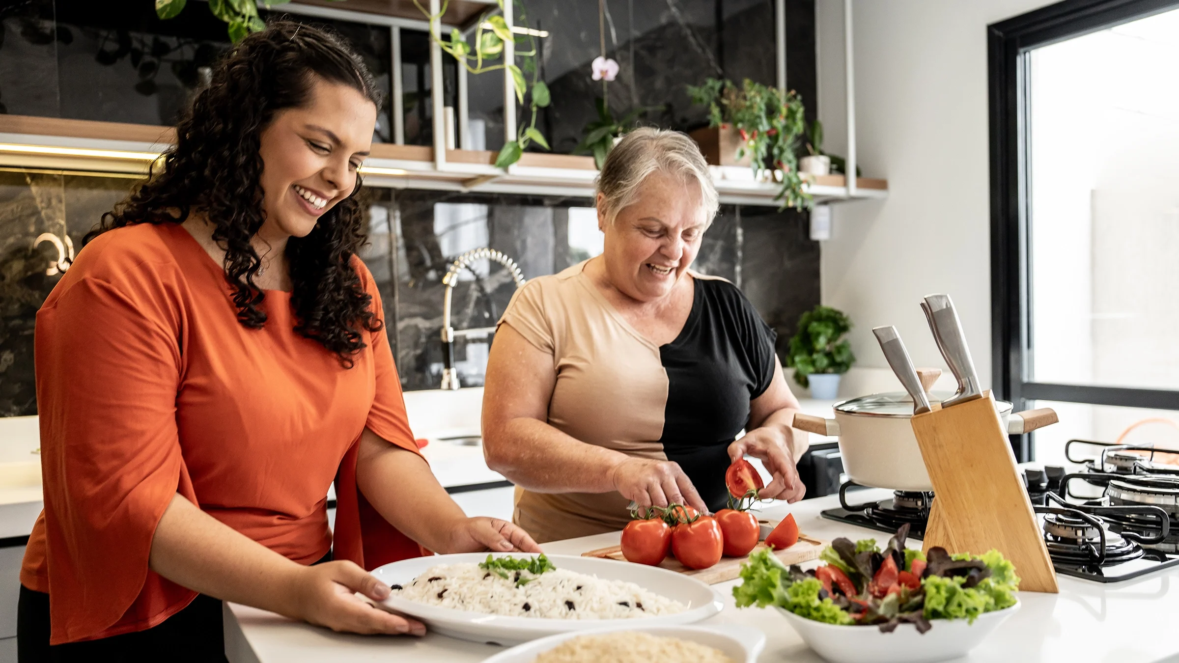 A mother and daughter prepare a meal in the kitchen.