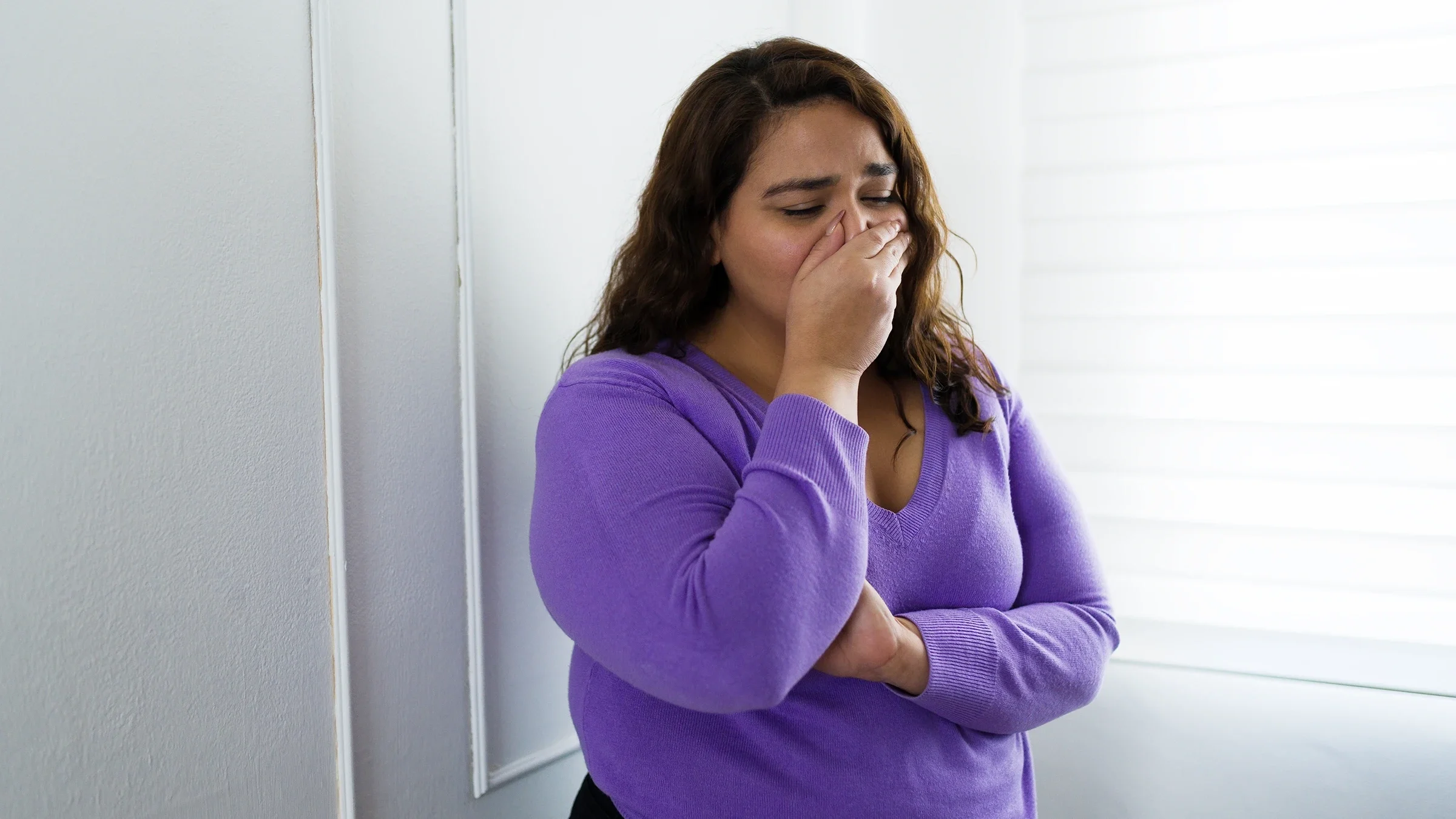 A woman cries at home.