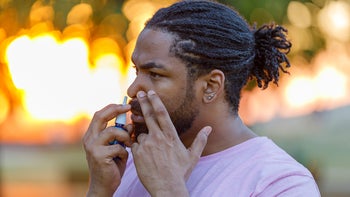 Health: Medication education: man using nose spray outdoors 1307899358