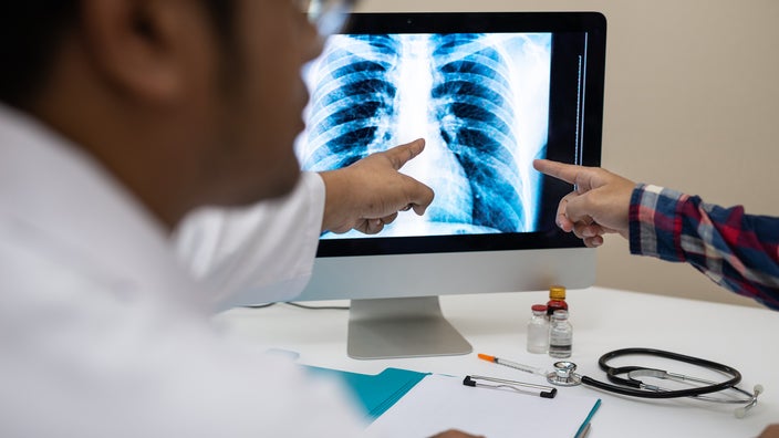A doctor is reviewing a chest X-ray on the computer with their patient.
