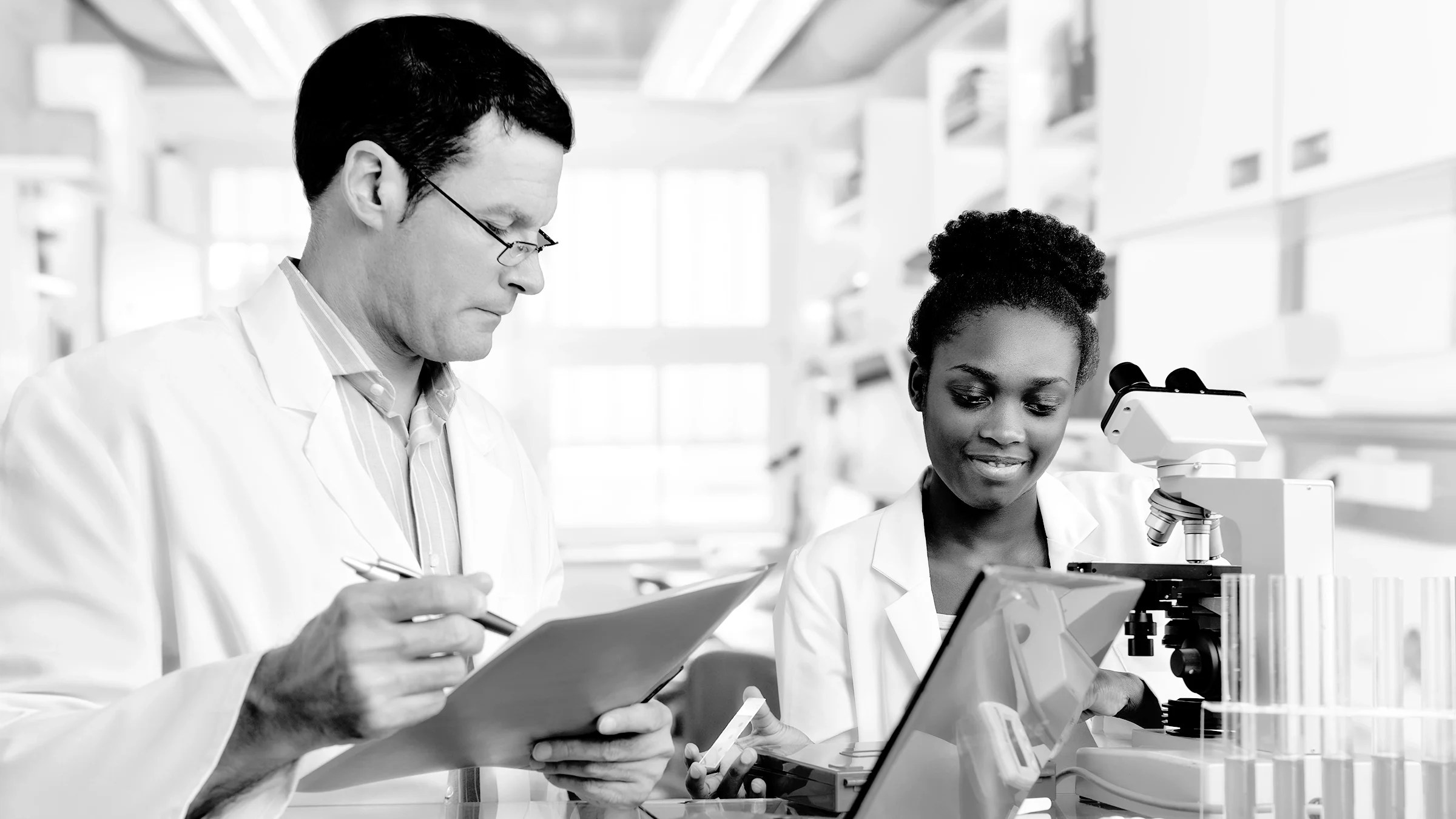 Black and white image of lab scientists going over test results.