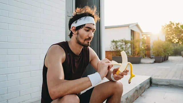 diet-nutrition: man eating a banana post workout 2276184345