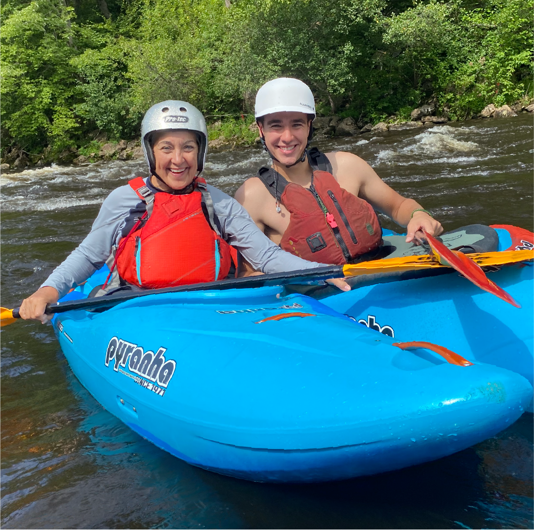 Jere Downs and her son kayaking down a river.