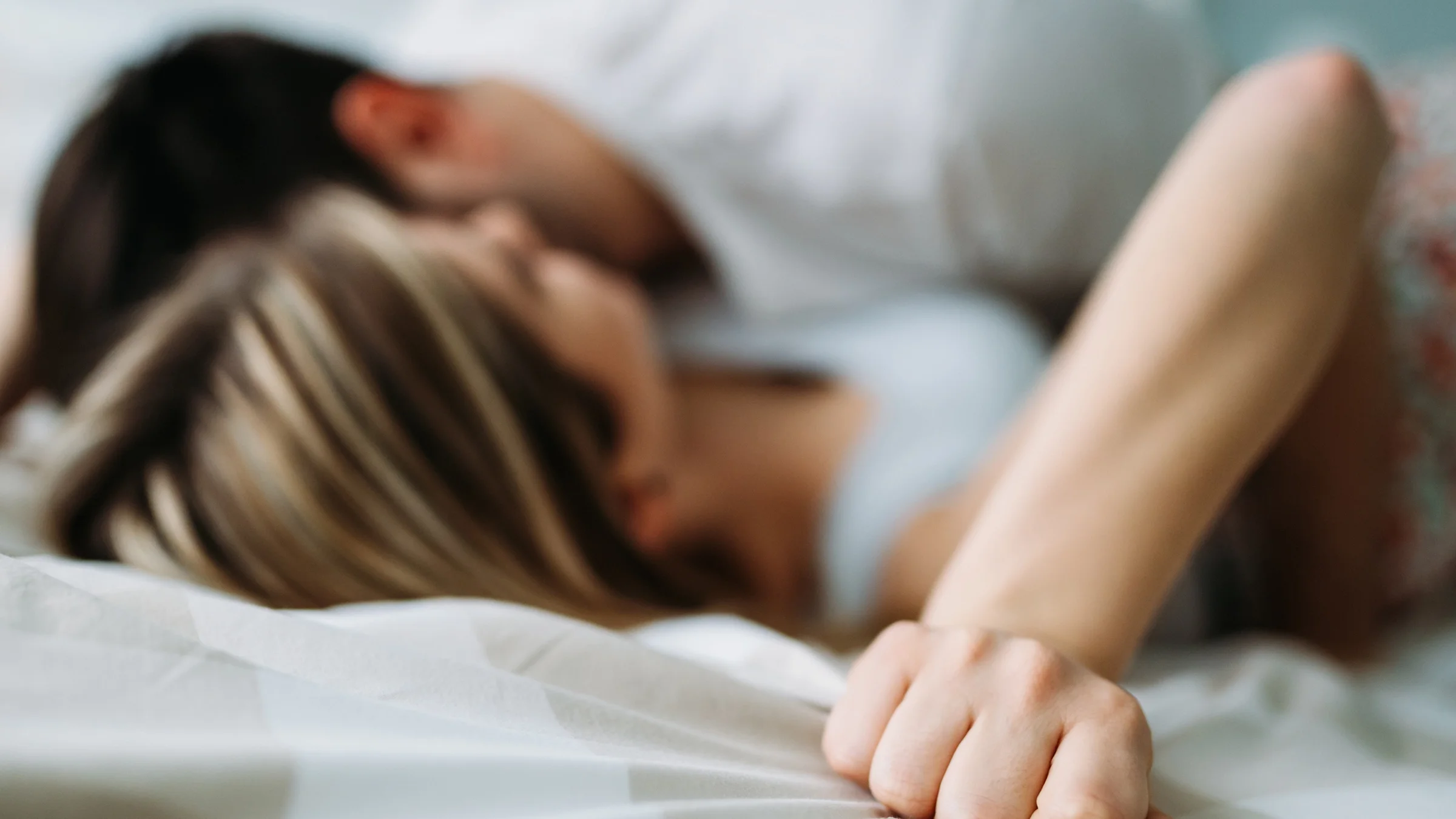 Blurred couple intimate in bedroom.