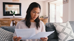 A woman reviews paperwork at home.
shapecharge/E+ via Getty Images