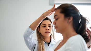 cancer: woman examining patients head 1143592130