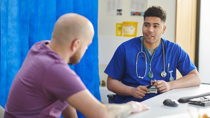 A HCP talking to a male patient.