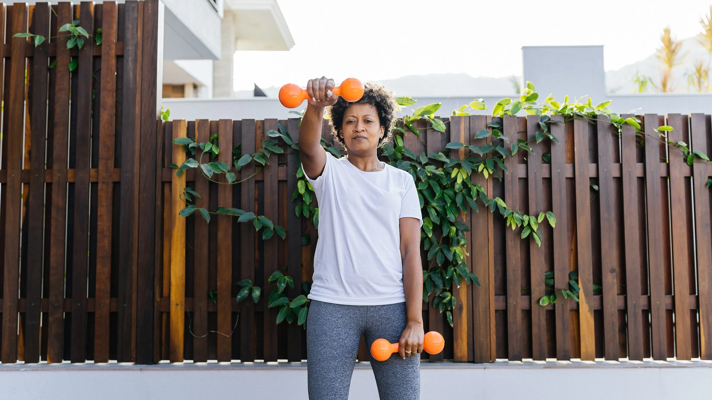 A woman lifts weights during a workout session. 