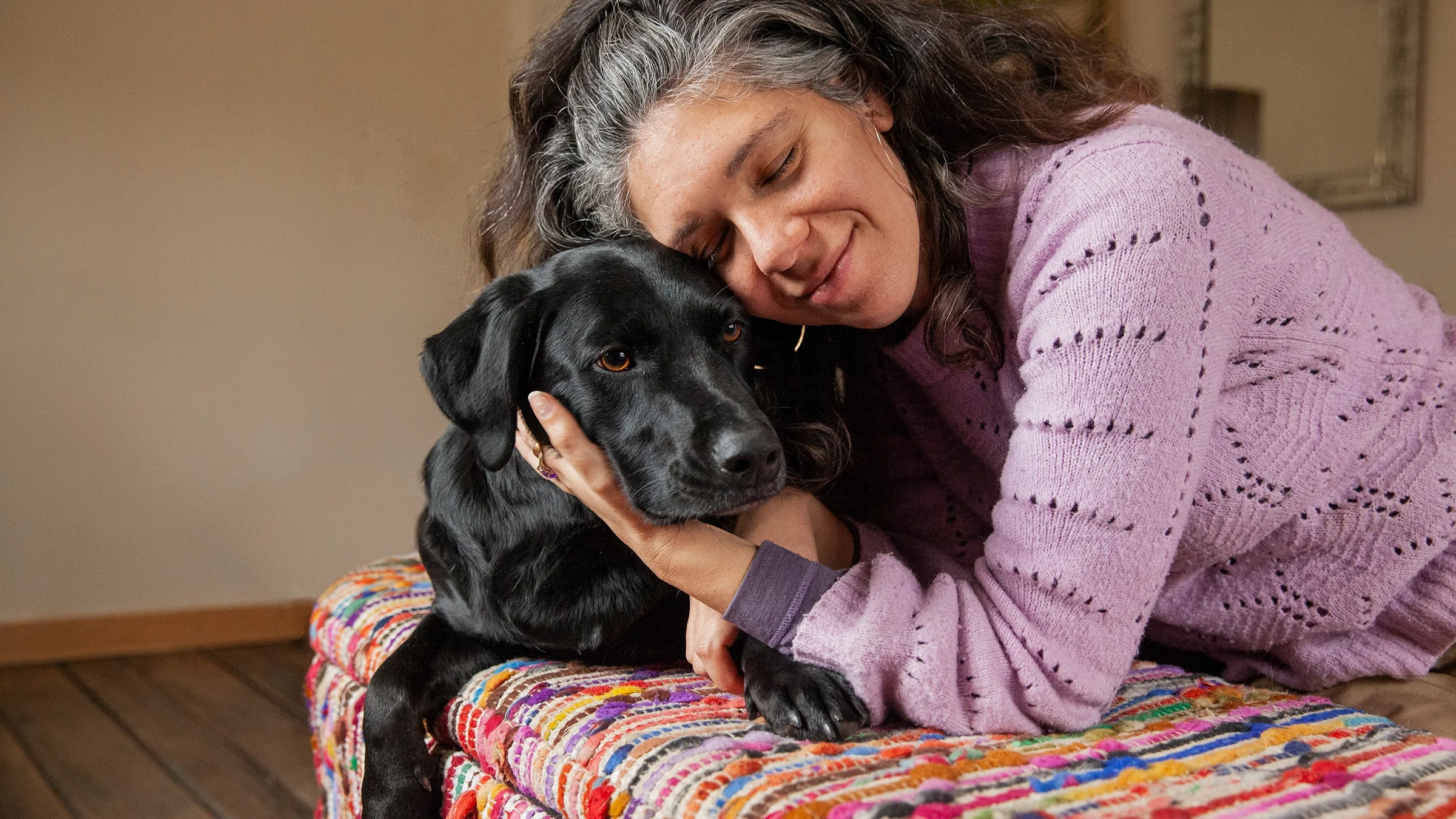 A woman hugs her dog.