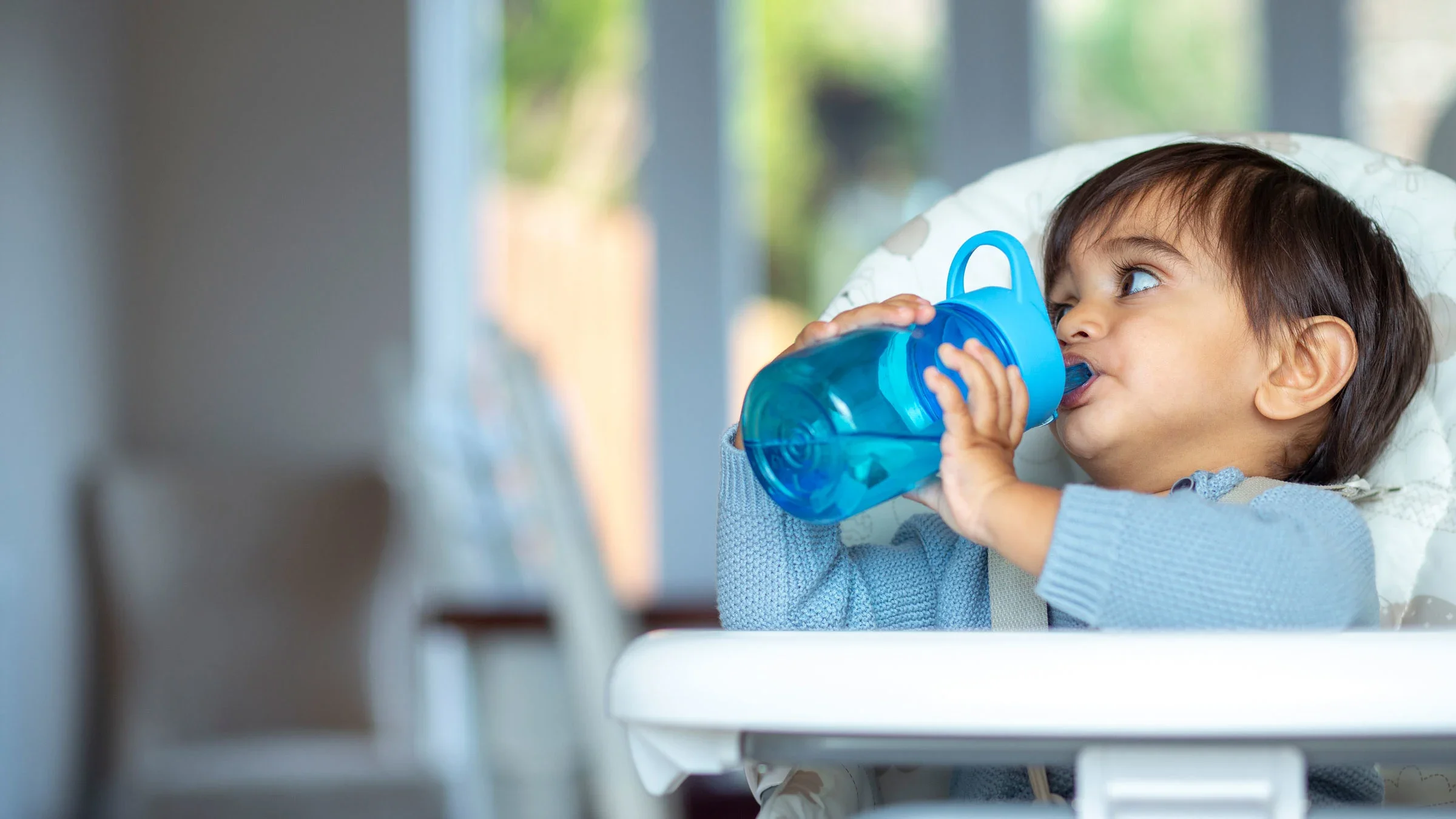 A toddler drinks out of a sippy cup. You can make homemade Pedialyte to treat dehydration in both children and adults.
SolStock/E+ via Getty Images