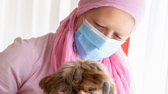 A cancer patient hugging their dog.
