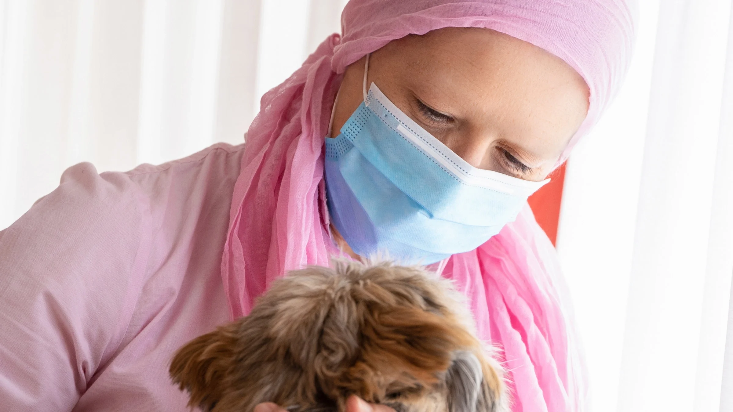 A cancer patient hugging their dog.