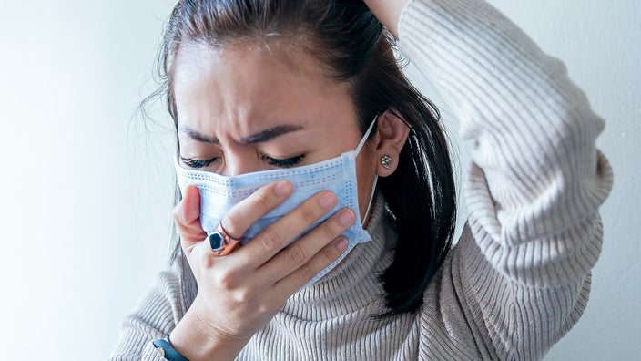 A Woman Using A Smartphone Wears A Medical Face Mask To Avoid The