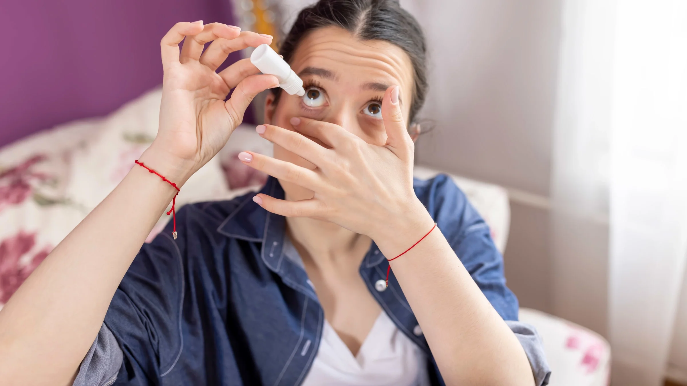 An adult using eye drops.