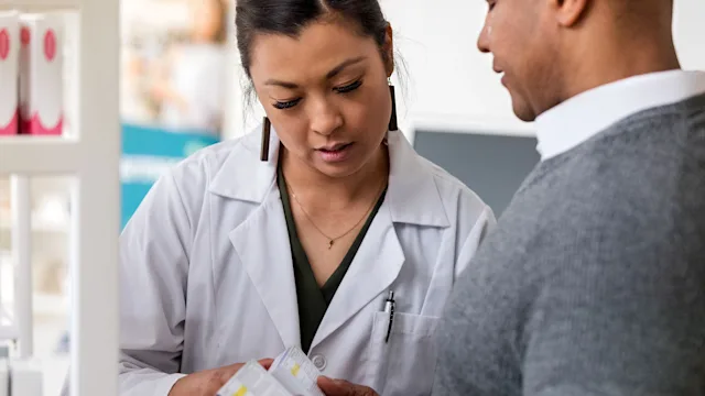 Medication Education: Pharmacists: customer asking pharmacist about medication 1165345340