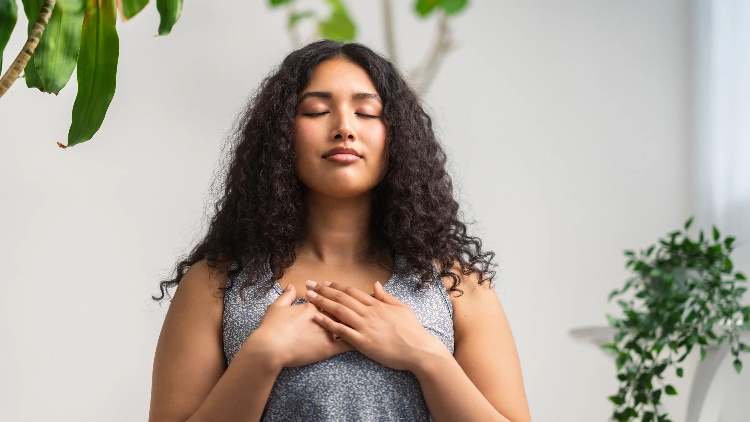 A woman stands in a meditative state, doing breathing exercises with text "Health Debunked" across the image.