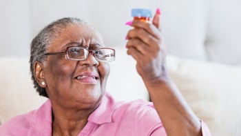 Health: Metoprolol: senior woman reading prescription bottle-1128768673