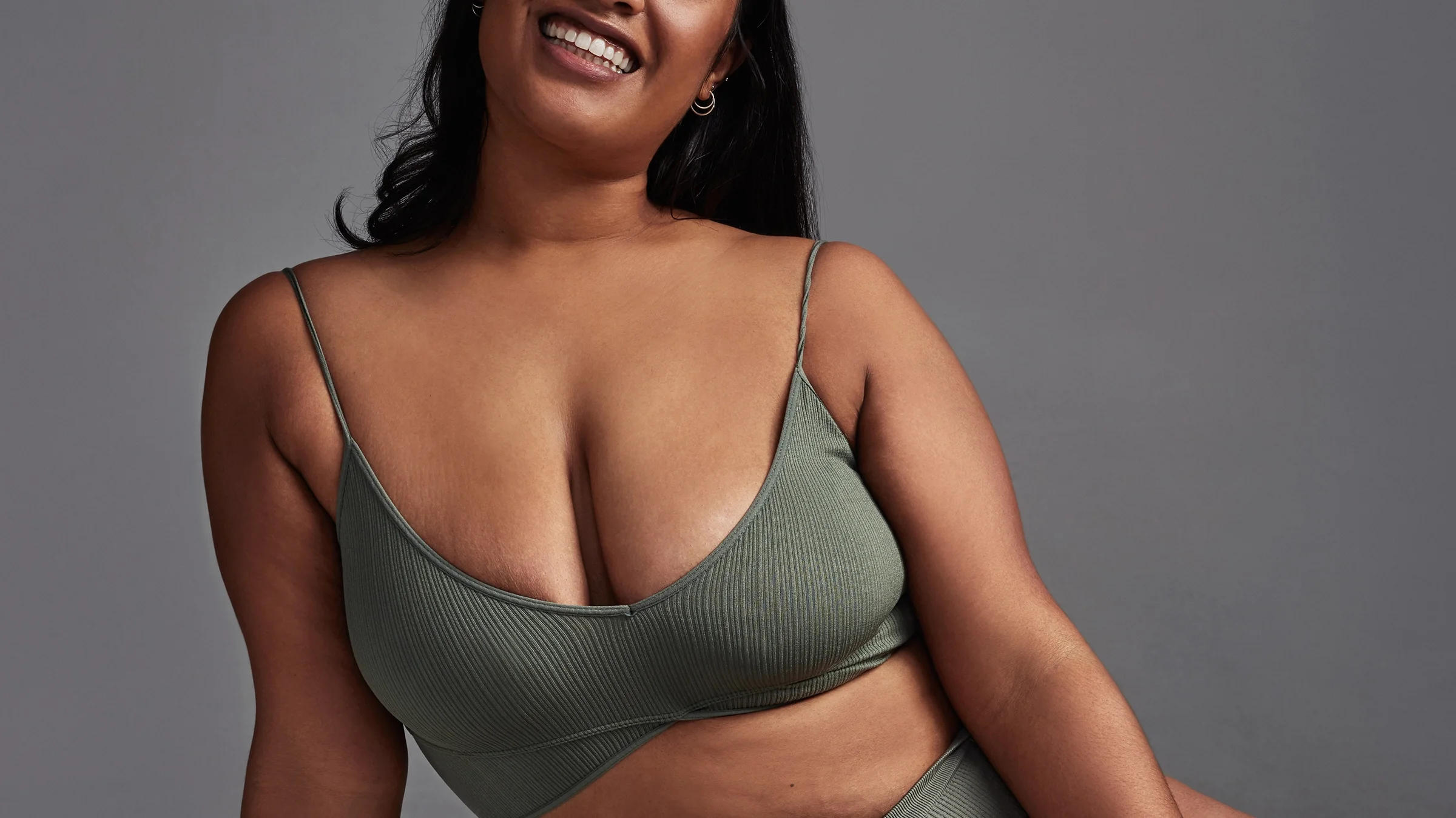 A woman is posing in her underwear in a close-up.