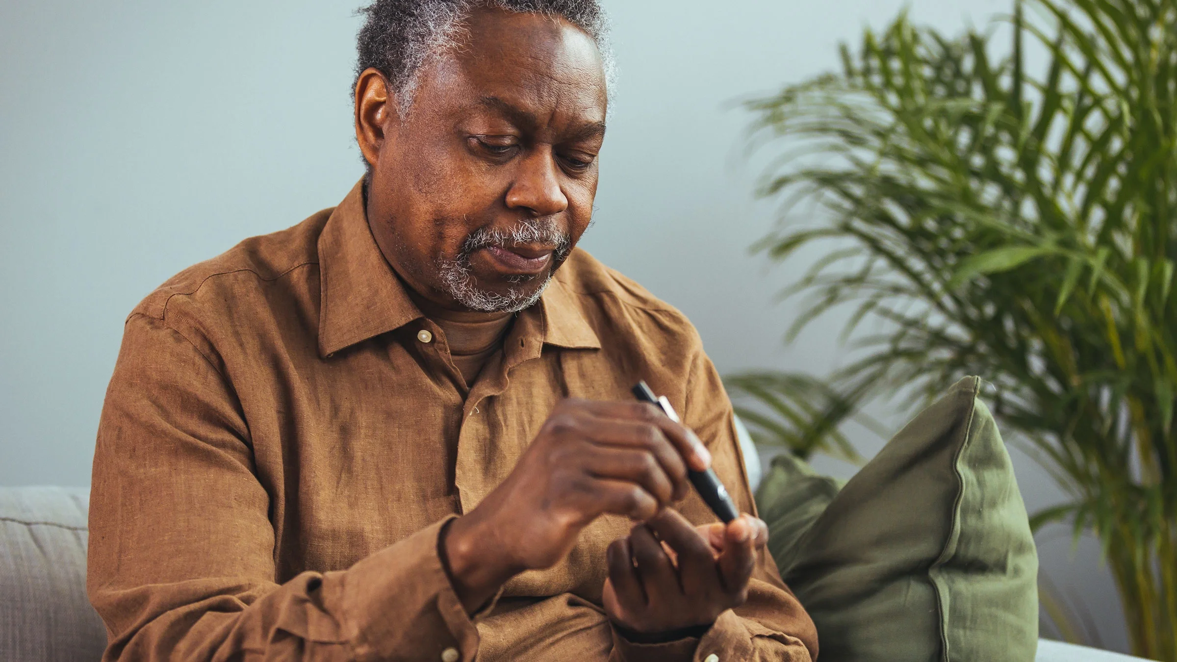 Older man checks his blood sugar.