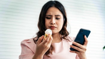 Hypothyroidism: woman reading Rx bottle 1717854408