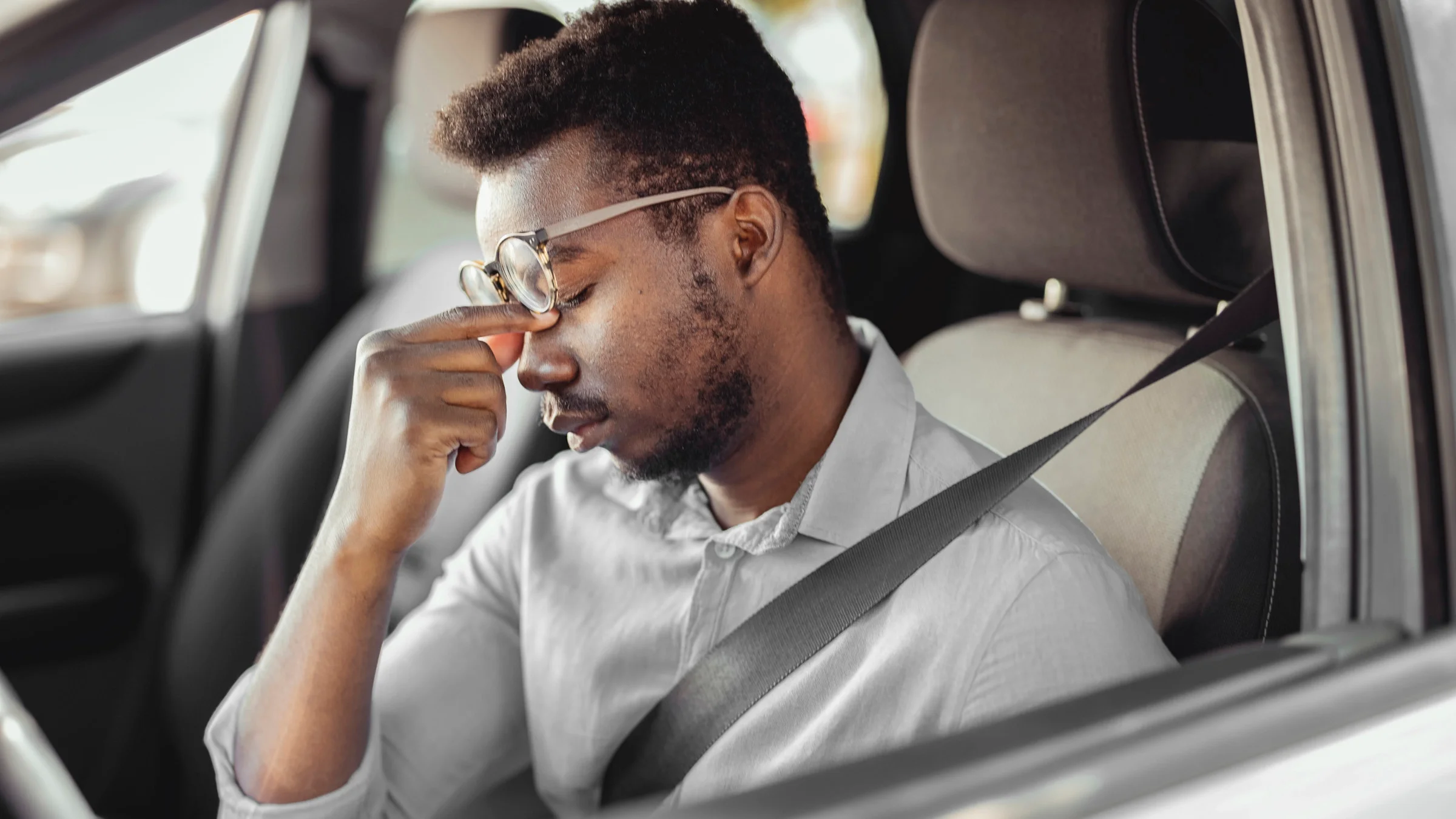 A man takes a break from driving due to eye pain.