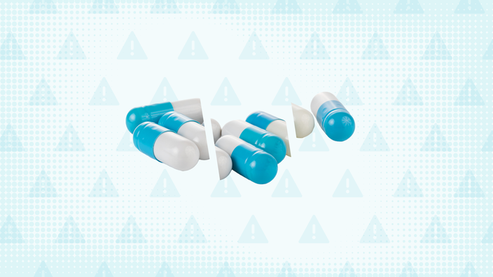 A custom graphic includes a teal background with a warning sign pattern and a pile of capsules cut into thirds.