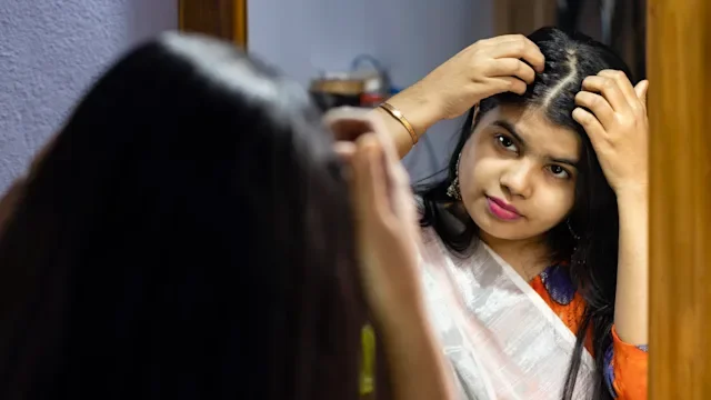 hair: woman examining hairline 1297044561