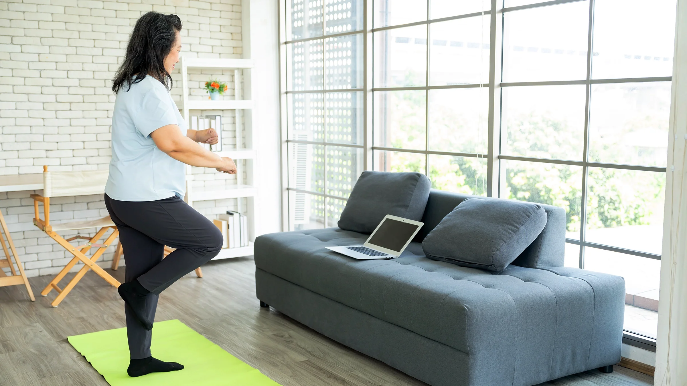A woman does a single leg balance exercise.
