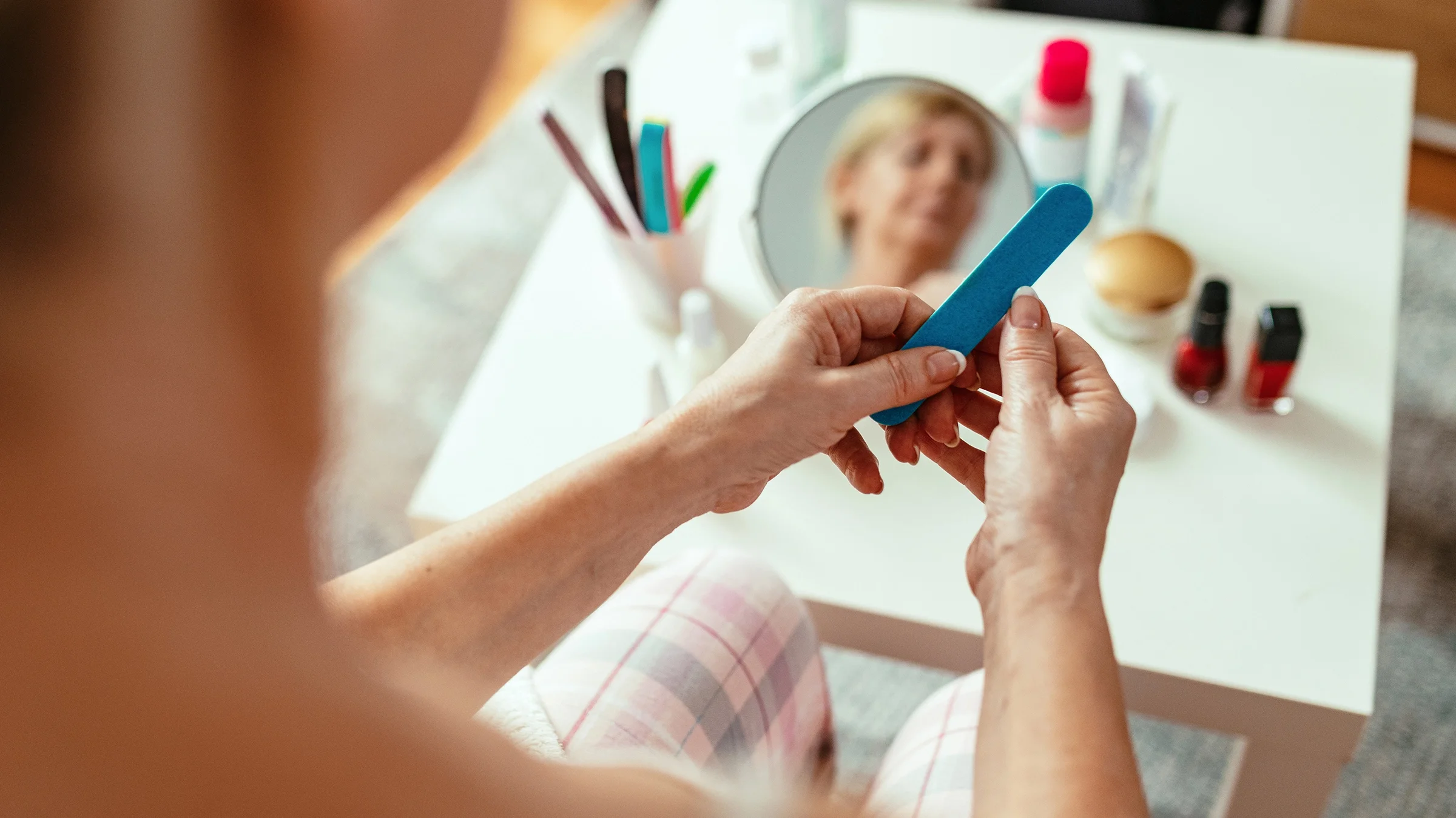 A woman files her nails.