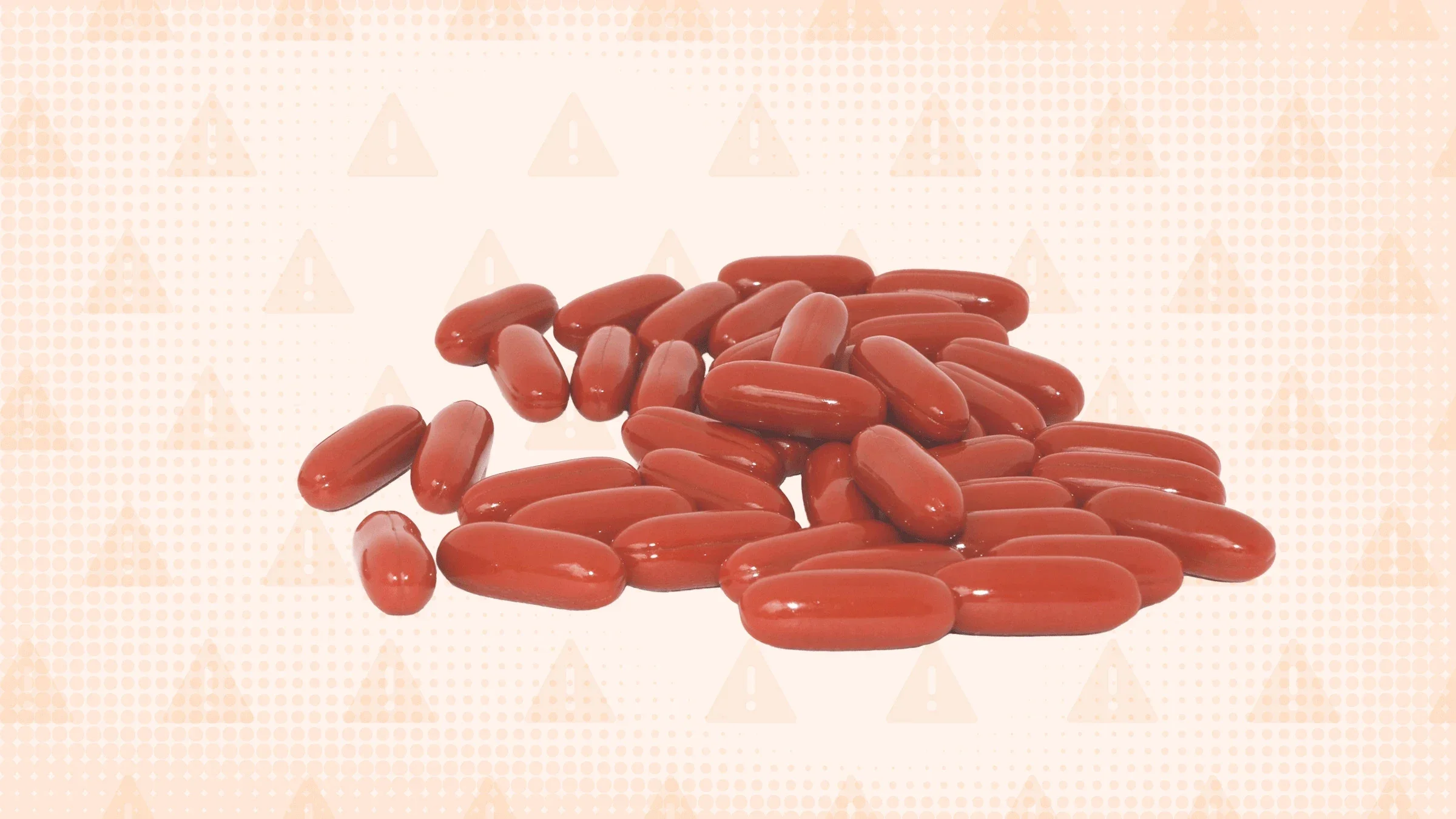 A graphic shows a pile of dark-red capsules against a light-orange, warning-sign background.
GoodRx Health