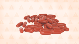 A graphic shows a pile of dark-red capsules against a light-orange, warning-sign background.
GoodRx Health