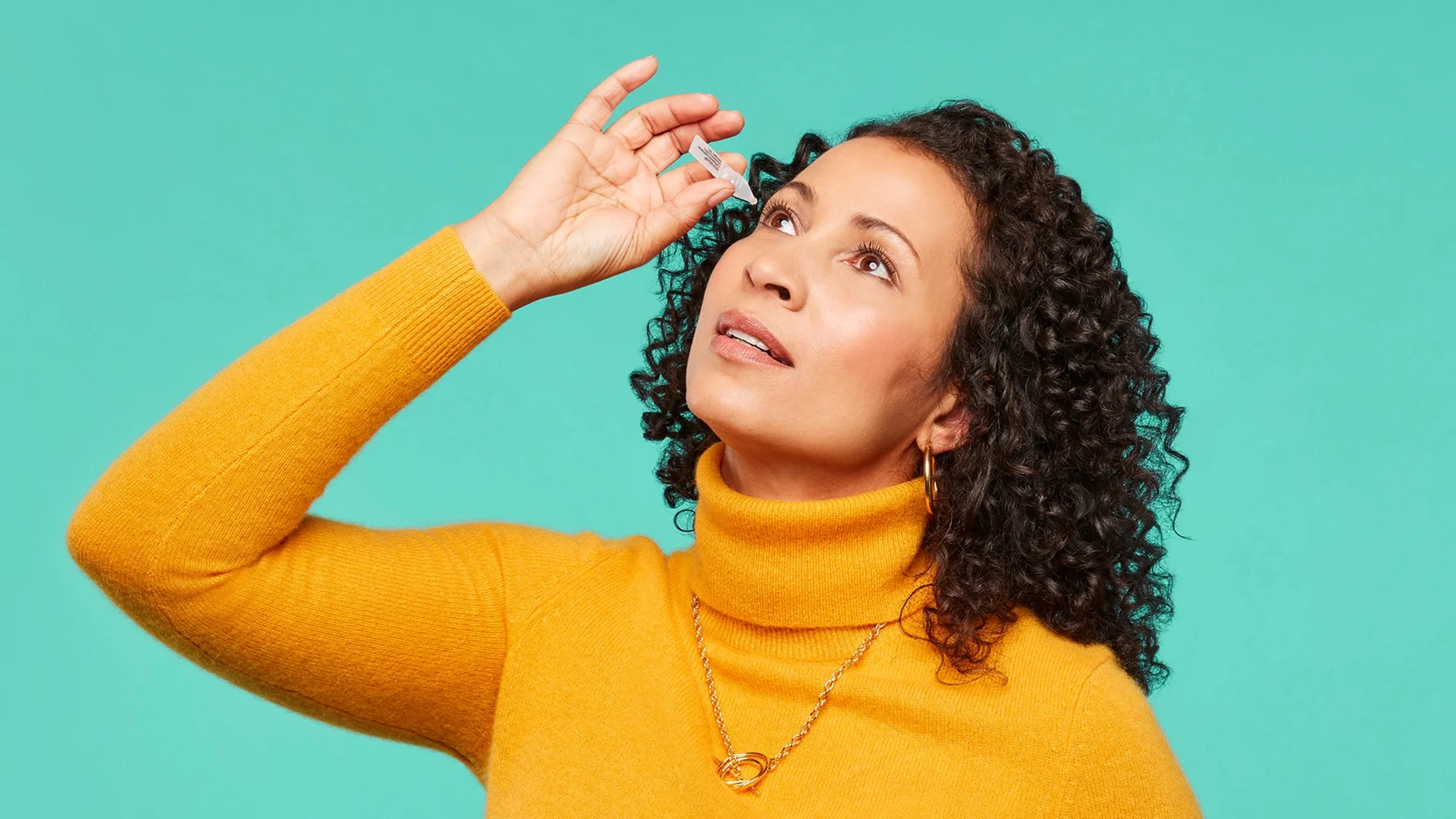 A woman uses Restasis eye drops.