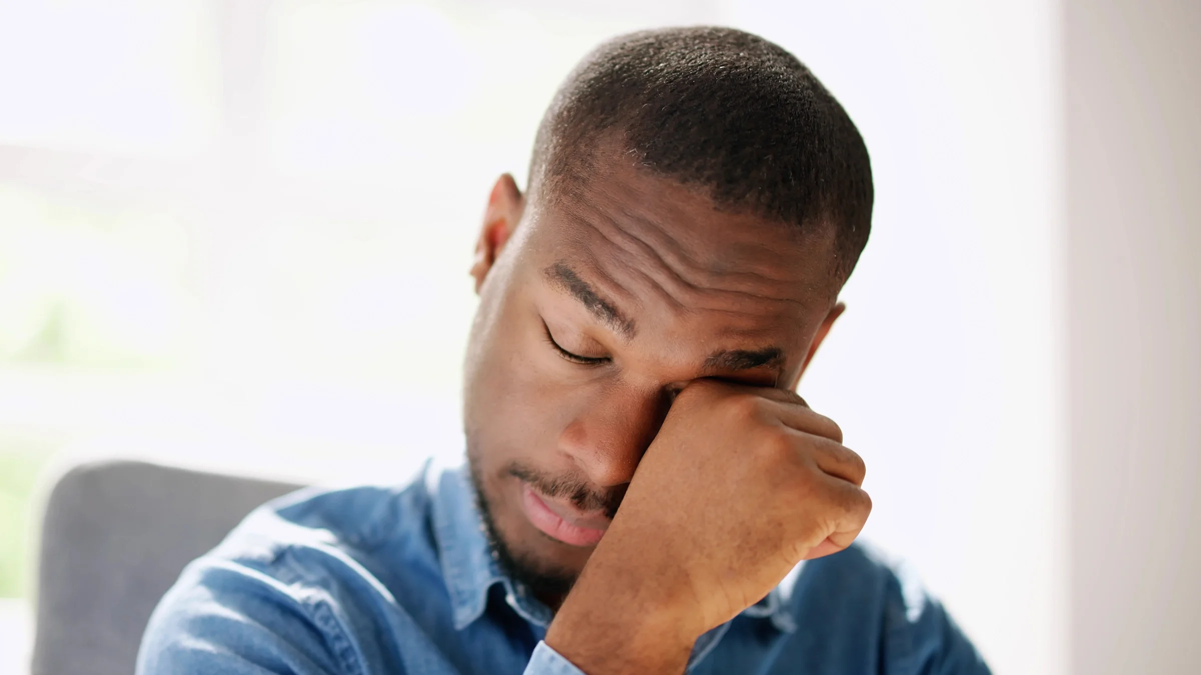 A man is rubbing his eye.