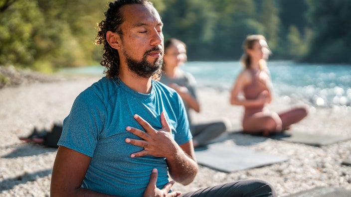 A man does a deep breathing exercise. 